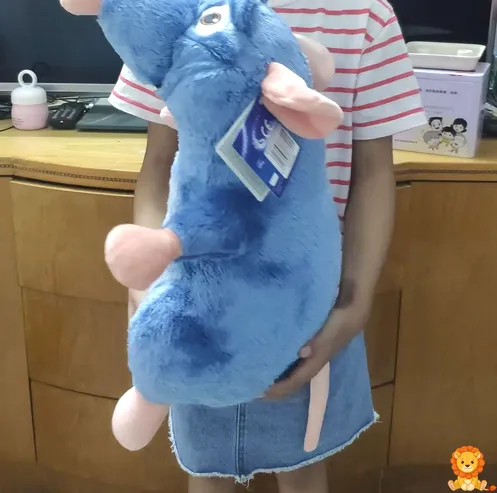 Grande peluche Ratatouille, vestido con su traje de chef, sosteniendo una cuchara, con una expresión amigable y detalles bordados de alta calidad. - View 2
