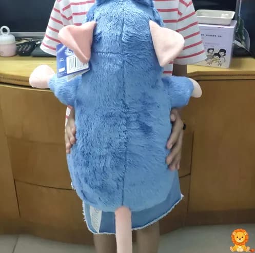 Grande peluche Ratatouille, vestido con su traje de chef, sosteniendo una cuchara, con una expresión amigable y detalles bordados de alta calidad. - View 3